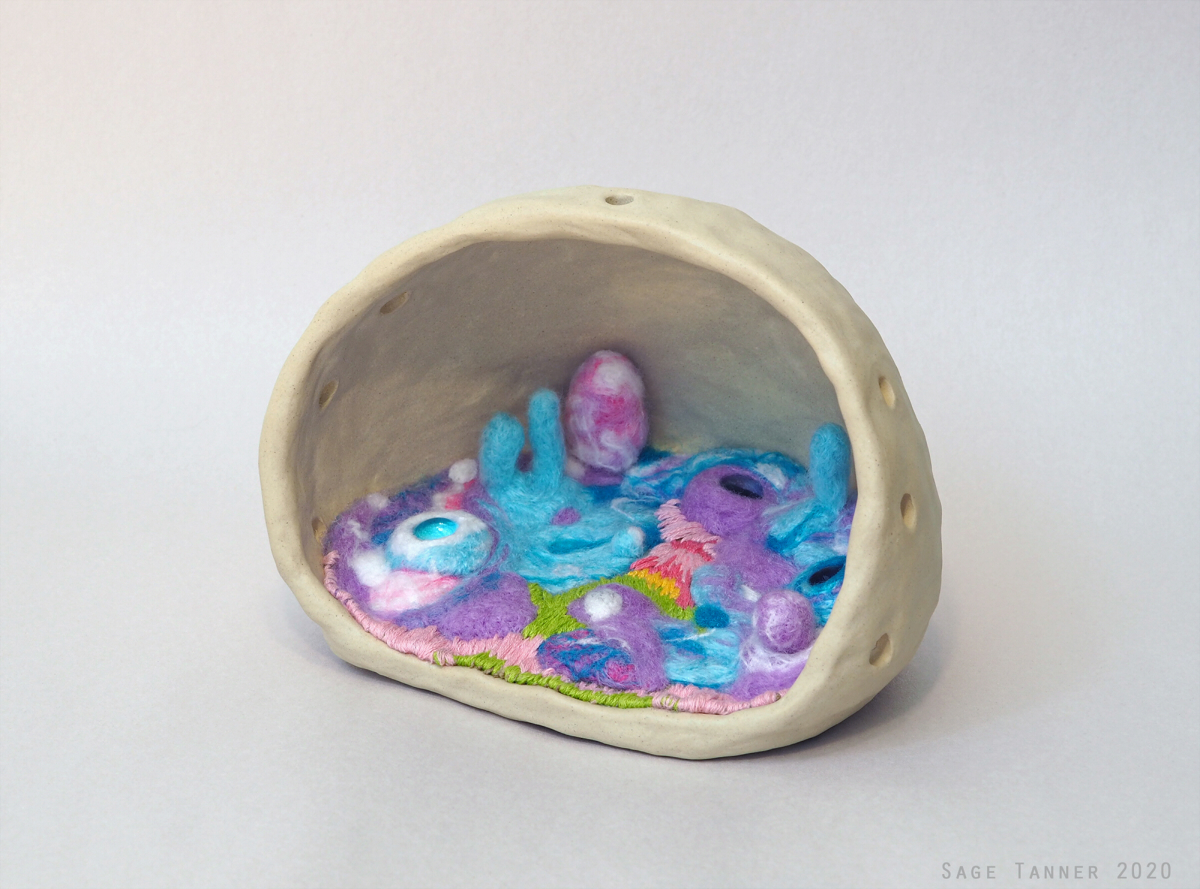 A doll with a cave-like ceramic form. The inside reveals a colorful landscape of abstract felt.